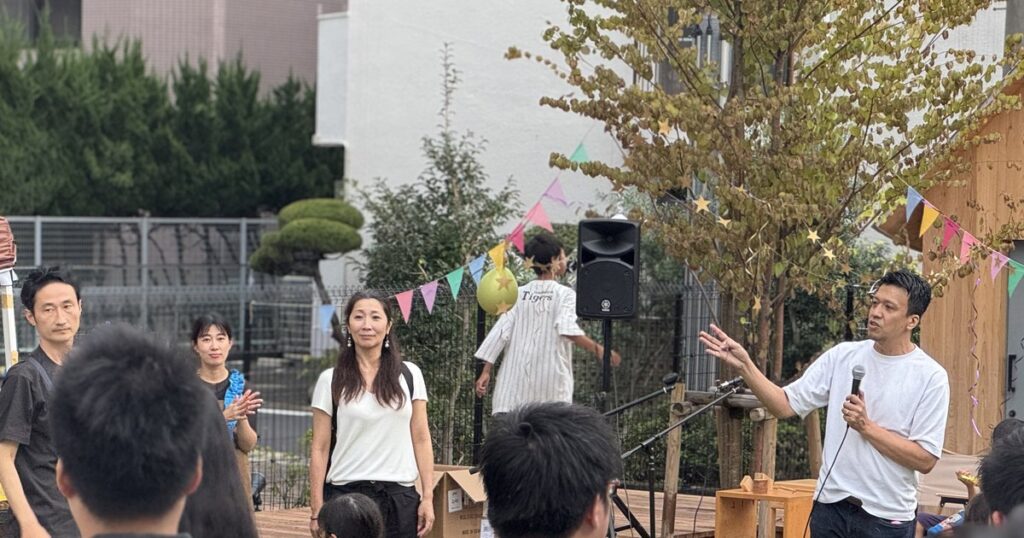 1周年感謝祭のステージでマイクを持って話す様子