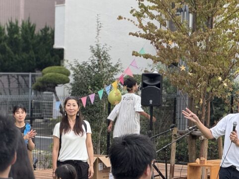 1周年感謝祭のステージでマイクを持って話す様子